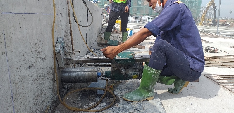 Kỹ thuật viên sử dụng máy khoan rút lõi bê tông thi công chính xác